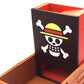 Close up shot of the Strawhats jolly roger on the face plate of the One Piece Dice Tower that is against a white background
