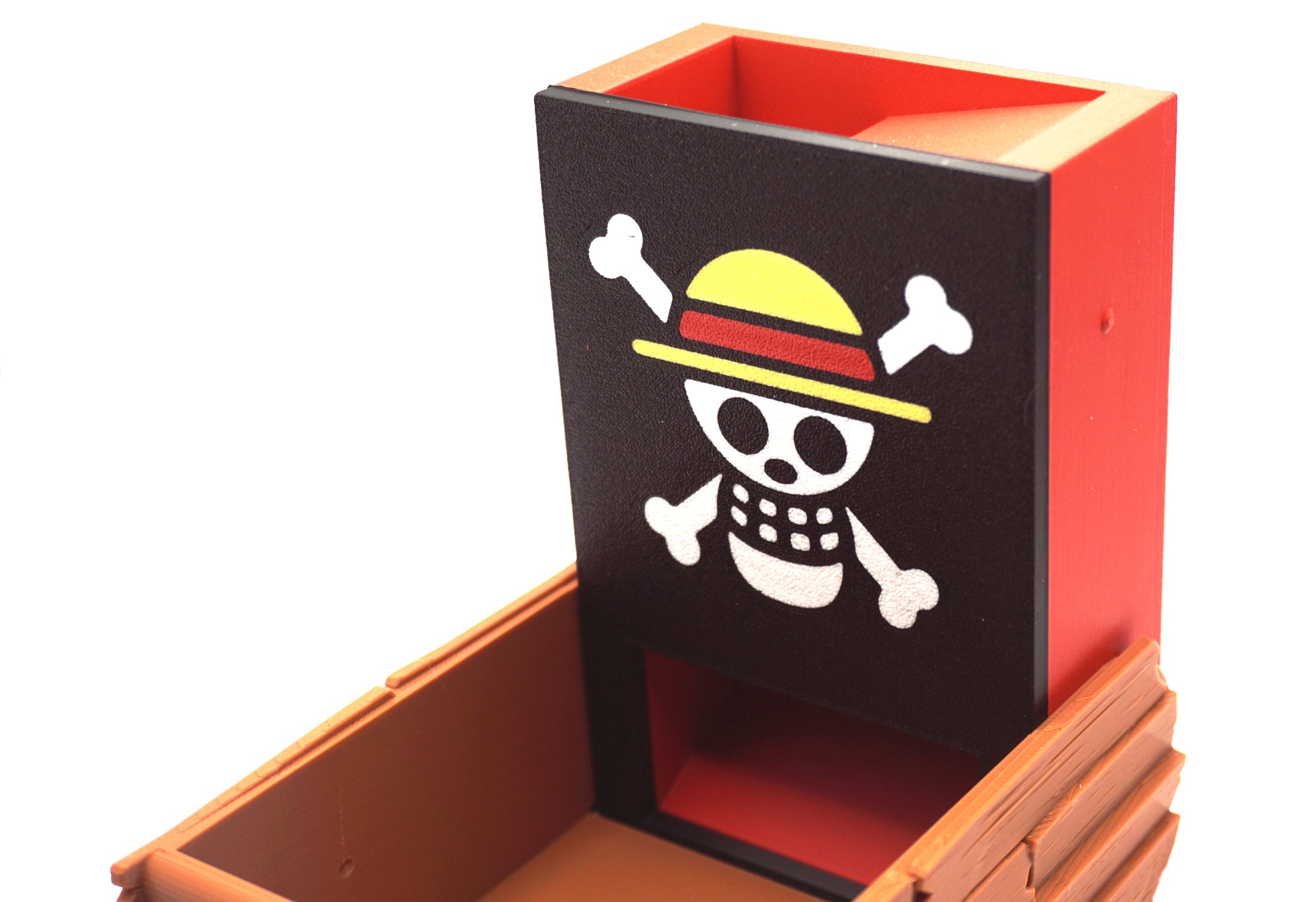 Close up shot of the Strawhats jolly roger on the face plate of the One Piece Dice Tower that is against a white background