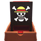 Front view of the One Piece Dice Tower showing the Strawhats jolly roger and the notch in the dice tray to open the dice tower when it's collapsed