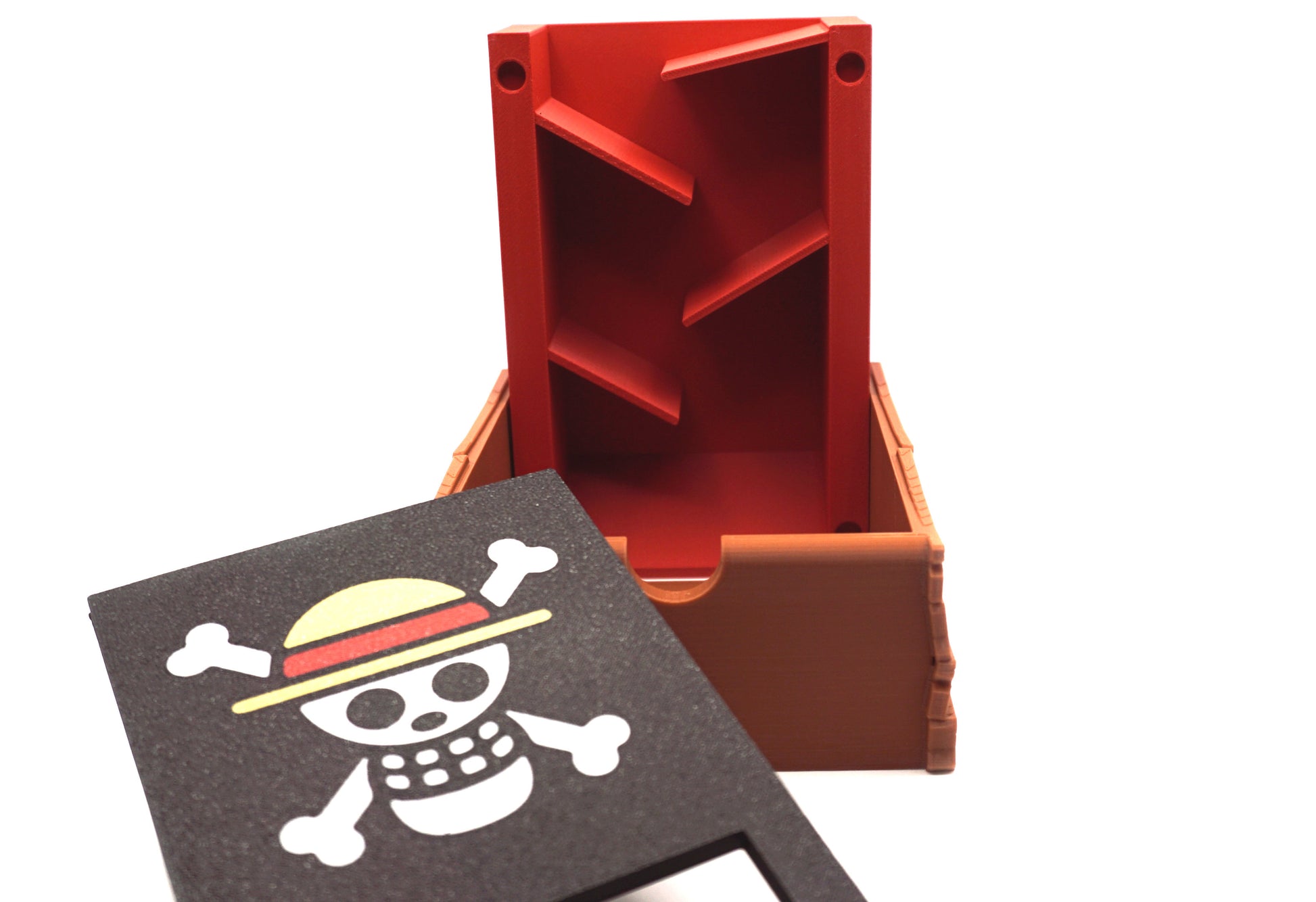 Showing the inside of the One Piece Dice Tower. The face plate has been taken off and set on the tray, showing the amount of randomizers inside the base of the tower