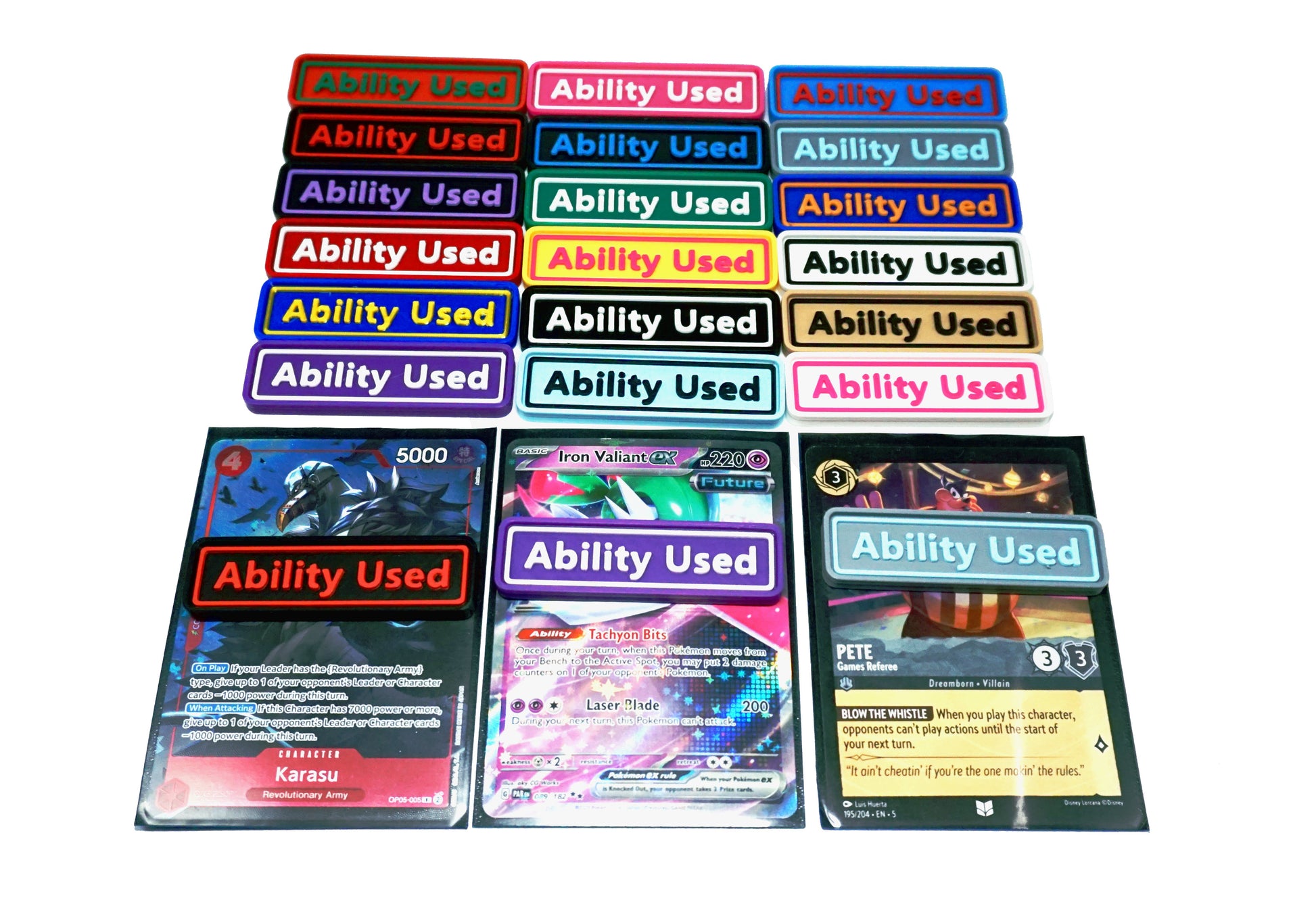 Ability Used markers for TCG and Tabletop gameplay. Shown in a variety of colors against a white background. Three of which are on top of cards from Pokemon, One Piece, and Lorcana