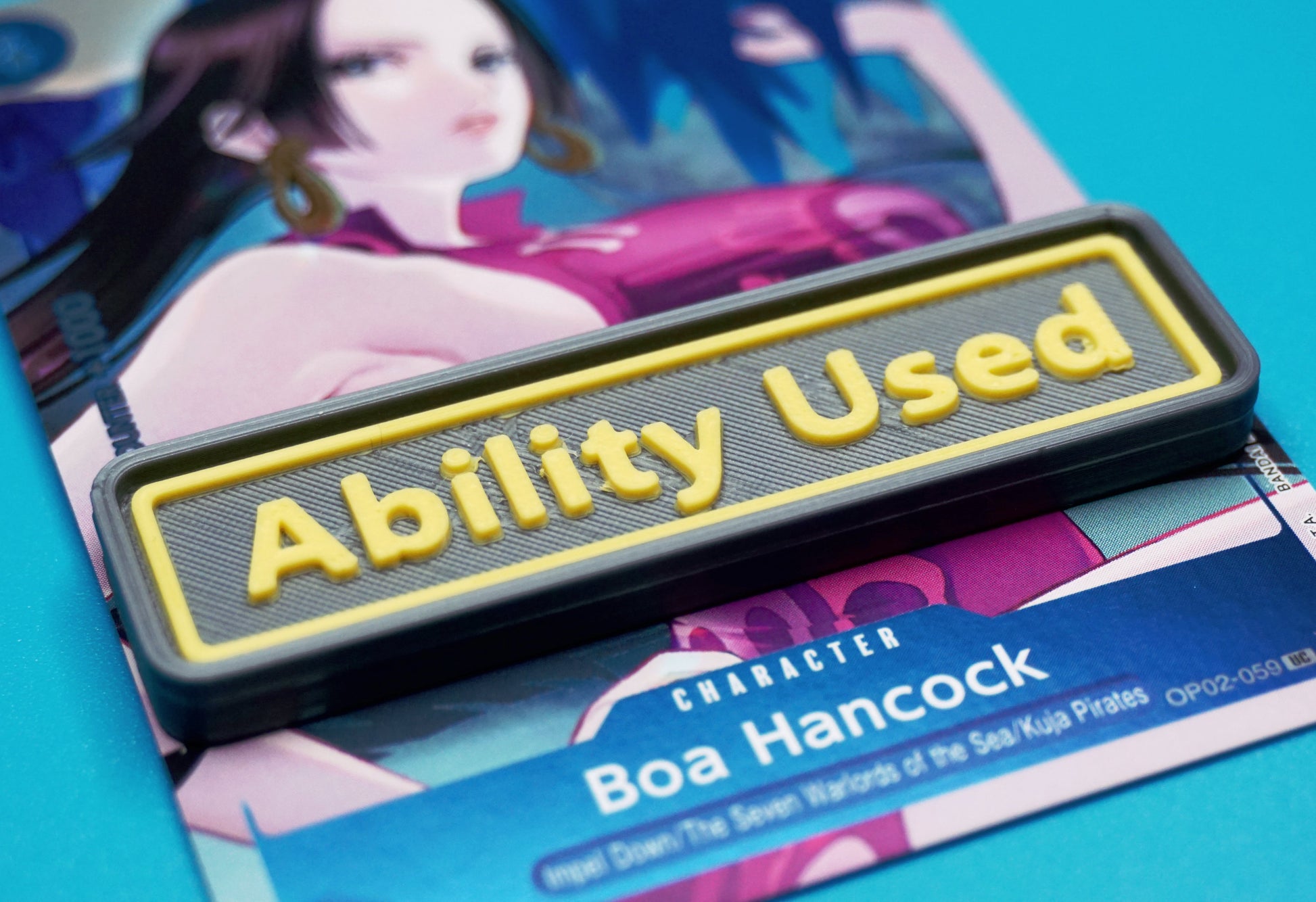 A black Ability Used marker with yellow text shown on top of a Boa Hancock card from the One Piece TCG.