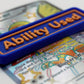 A blue Ability Used marker with orange text shown on top of a Shiny Pidgeot card from the Pokemon TCG.
