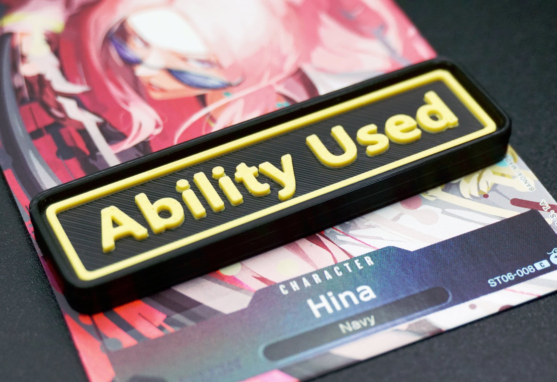A black Ability Used marker with yellow text shown on top of a Hina card from the One Piece TCG.