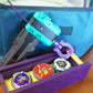 The Slip Grip in purple attached to the teal rip cord launcher next to the purple garage door style deckbox with 3 beyblades inside