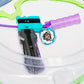 The Beyblade X Full Grip Handle in purple on the teal ripcord launcher with grey handle. Next to a Pegasus Blast CX beyblade in the Takara Tomy Stadium