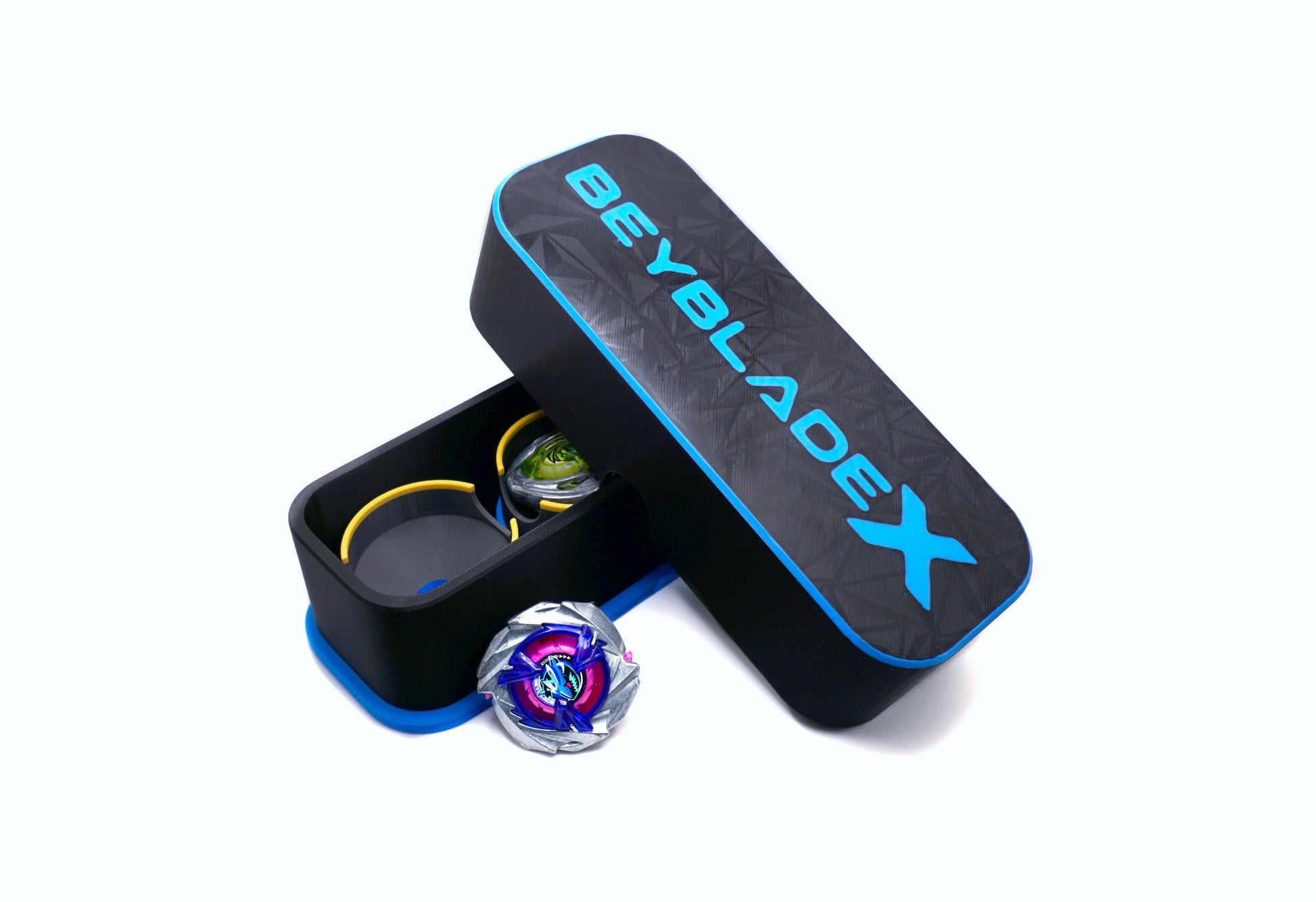 The Beyblade X Deckbox from Momo's Models shown in Black and Sky Blue with the Shark Scale and Hover Wyvern Pringle beyblades against a white background