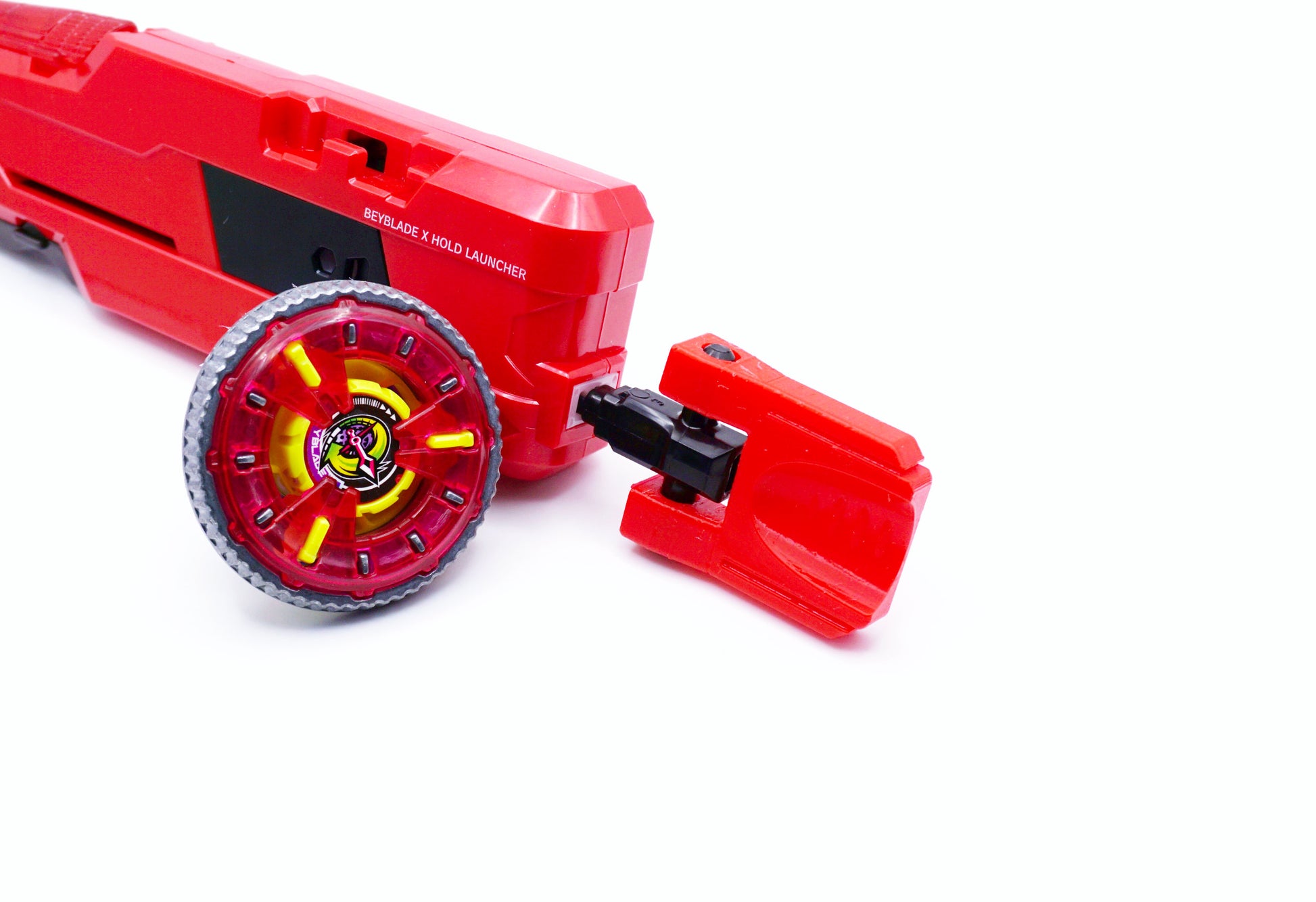 The red emperor full grip launcher with the cherry Thumb Tab next to the Clock Mirage beyblade against a white background