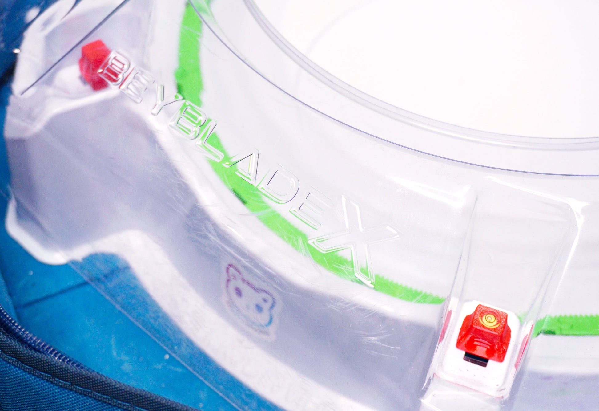 Stadium Level Locks in Cherry on the Takara Tomy Beyblade X stadium. With the stadium in a blue case with a sticker for Momo's Models on the front.