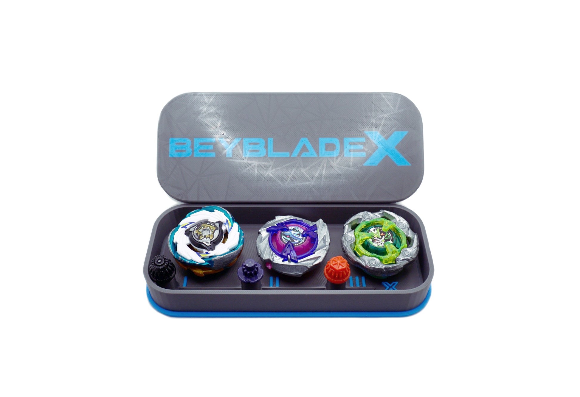 The Beyblade X Pocket deck box in grey and sky blue. Currently open revealing the three beys inside which include Emperor Pegasus Blast Heavy 3-60 Level, Shark Scale 1-70 Low Rush, and Wizard Rod (Wand Wizard) 1-60 Hexa