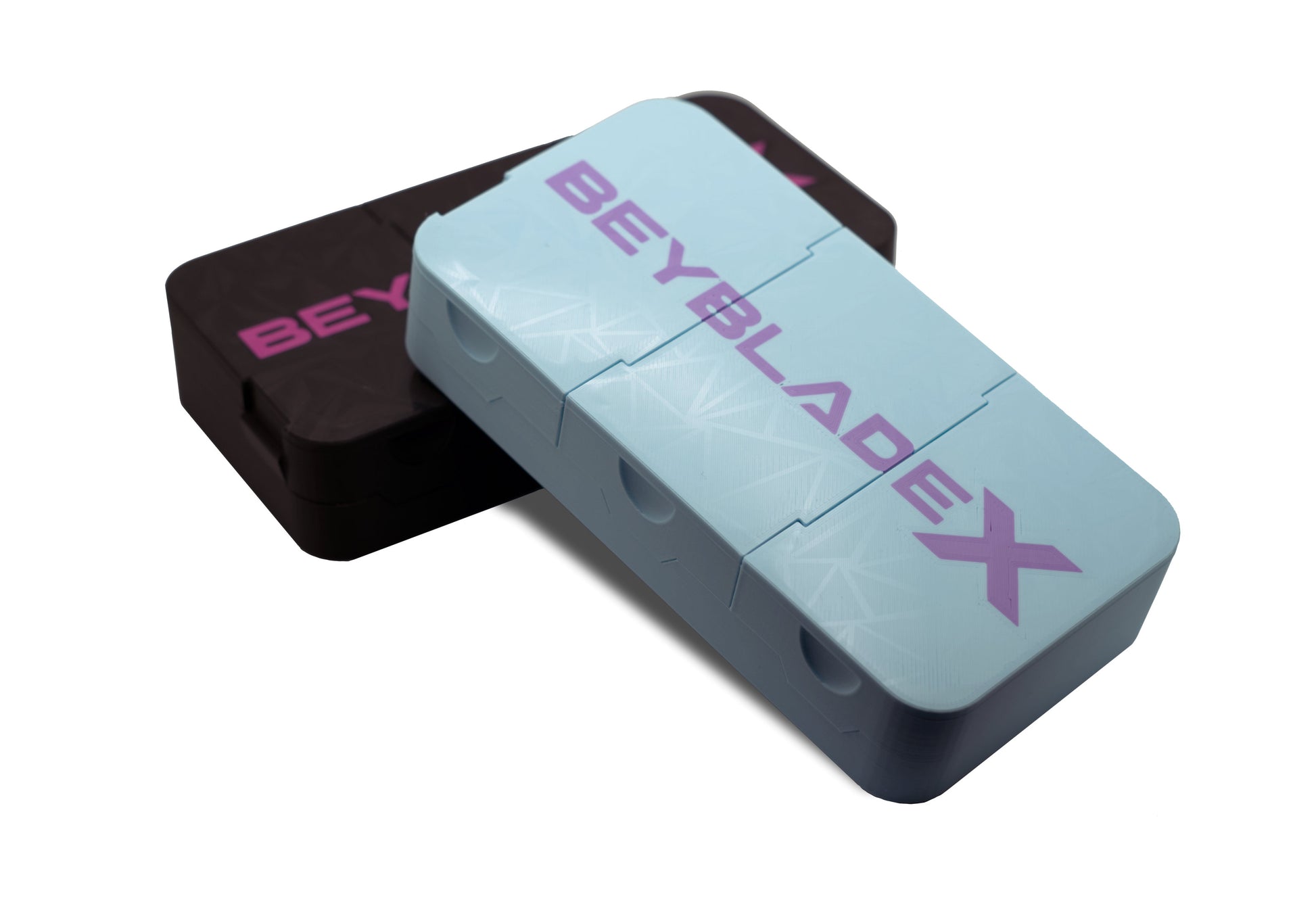 The Beyblade X Pocket Clam Shell Deck Boxes one shown in black and hot pink and the other in Glacier and Lavender. With one of them resting over the other