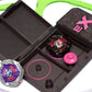 The Beyblade X Pocket Clam Shell Deck Box shown in black and hot pink. Sitting inside a Takara Tomy Extreme Stadium with Shark Scale and Mammoth Tusk beyblades
