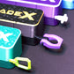 Close up shot of multiple Slam Shell EX deck boxes in a variety of colors sitting on a black table. Each with a ripcord slid through them to keep them closed