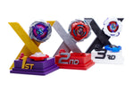 Trophy Stands for Beyblade X. Displaying 1st in gold purple with Shark Scale 1-70 low rush; 2nd in silver red with Bullet Griffon hexa; and 3rd in black white with Meteor Dragoon 7-70 level