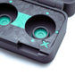 Close-up of a black 3D-printed protective case with two circular cutouts, featuring bright teal accents, a small star-shaped cutout, and a textured geometric pattern on a white background.