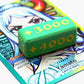 Attack Increase marker shown in grass and yellow on top of a Yamato full art leader card for One Piece TCG