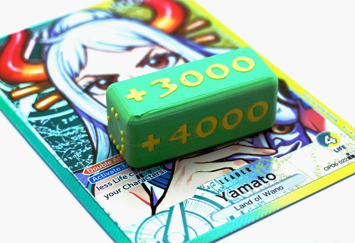 Attack Increase marker shown in grass and yellow on top of a Yamato full art leader card for One Piece TCG