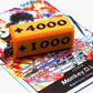 Attack Increase marker in orange and black on top of a Monkey D Luffy alt art leader card for One Piece TCG
