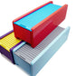 The Beyblade X Garage Door style deckbox from Momo's Models shown in purple and yellow color scheme, red and sky blue color scheme, and the glacier with grey color scheme. With everything against a white background