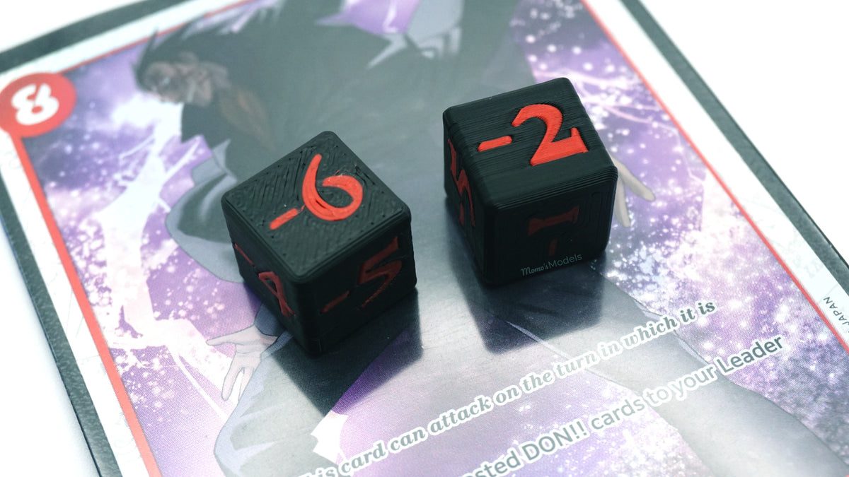 Multiple Mini Negative Dice in black and red with -6 and -2 shown on top of a Dragon card from the One Piece TCG