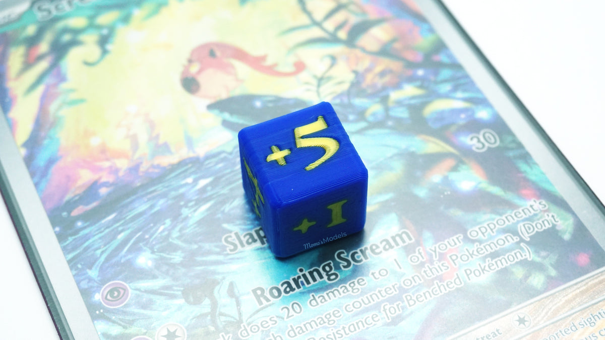 Mini Positive Dice shown in blue and gold with +5 on it placed on a Pokemon card