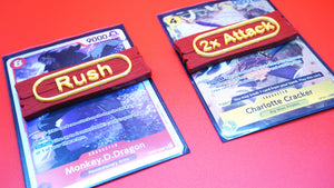 Rush and 2x Attack Ability Marker shown in red and yellow on top of multiple cards from the OPTCG
