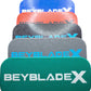 A stack of five Beyblade Pocket deck boxes in shades of green, black, red, gray, and blue. Each deck box features a geometric pattern and the text "BEYBLADE X" in white, black, or sky blue.