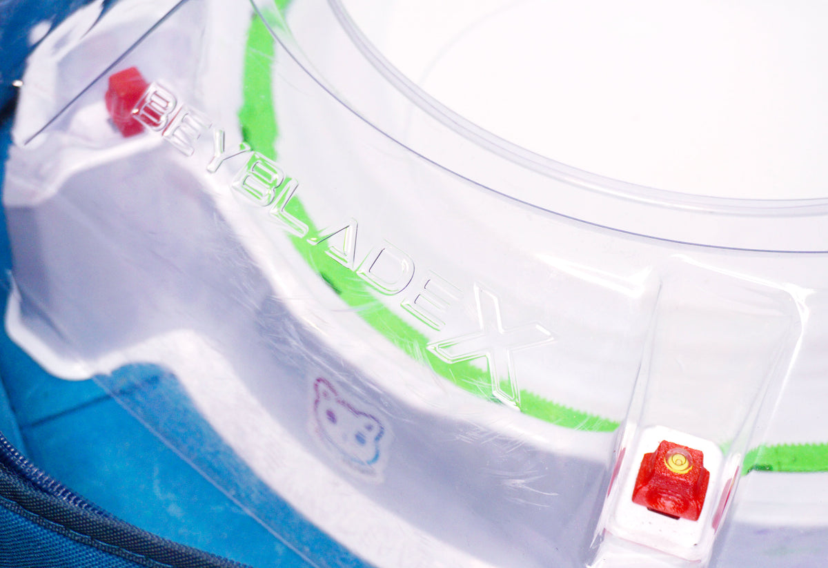 Stadium Level Locks in Red on the Takara Tomy Beyblade X stadium. With the stadium in a blue case with a sticker for Momo's Models on the front.