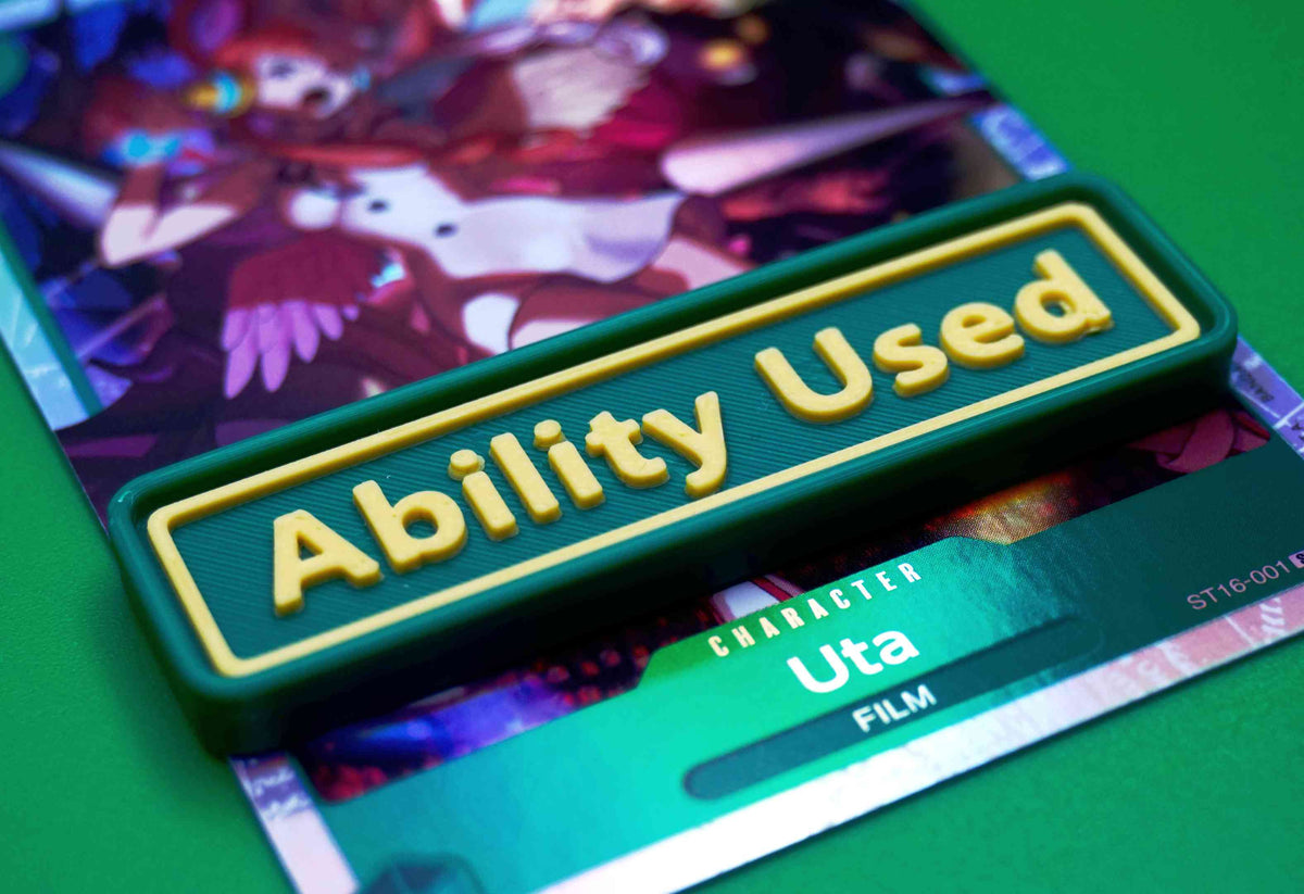 A green Ability Used marker with yellow text shown on top of a Uta card from the One Piece TCG.