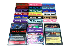 Ability Used markers for TCG and Tabletop gameplay. Shown in a variety of colors against a white background. Three of which are on top of cards from Pokemon, One Piece, and Lorcana