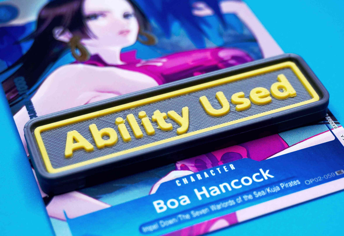 A black Ability Used marker with yellow text shown on top of a Boa Hancock card from the One Piece TCG.