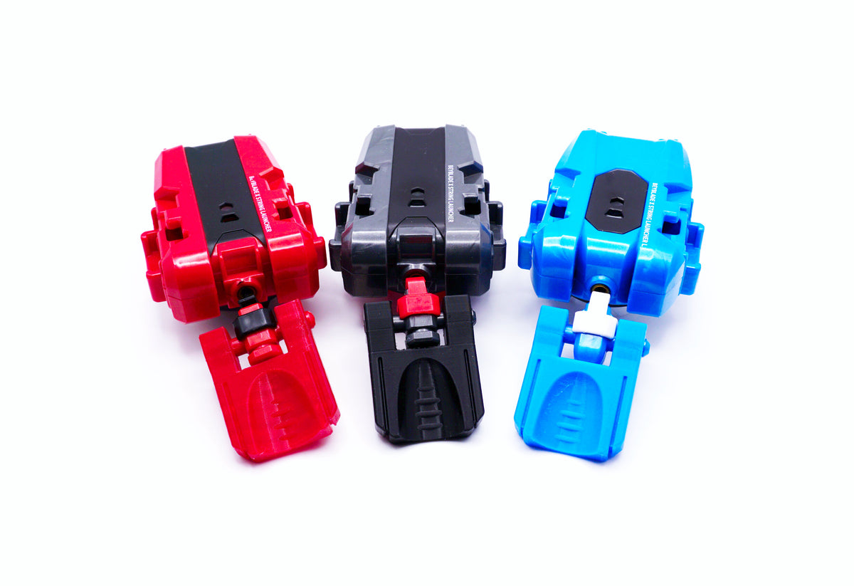 The Thumb Tab or thicc boi launcher attachment on 3 different string launchers for Beyblade X, colors shown are red, black, and sky blue against a white background